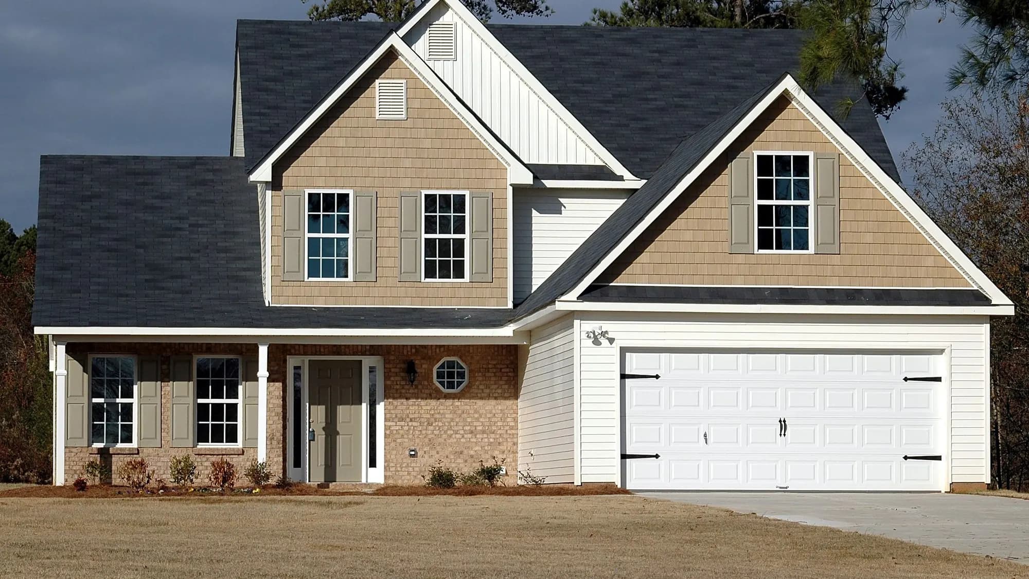 Two-storey suburban family home with a covered porch on a quiet residential street — the kind of home we insulate in Elgin, IL