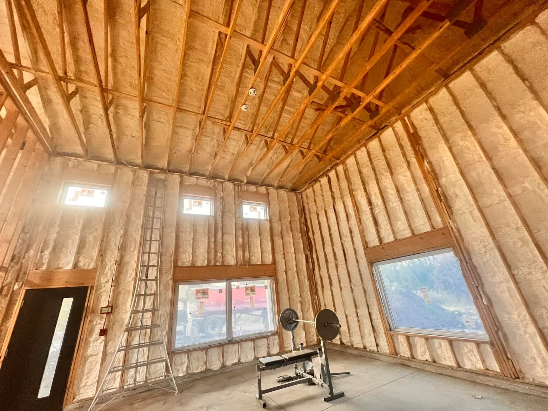 Open cell spray foam insulation covering the walls and cathedral ceiling of a new home near Elgin, IL