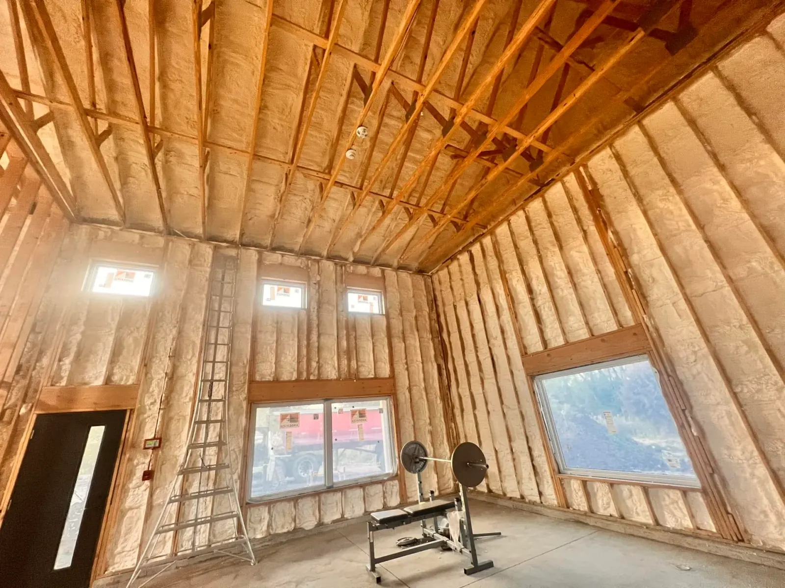 Open cell spray foam insulation covering the walls and cathedral ceiling of a new home near Elgin, IL